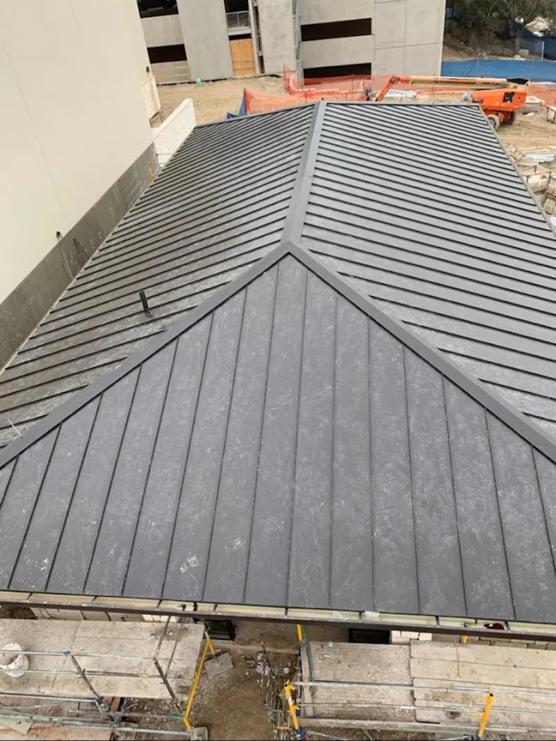 Commercial metal roof construction with crane equipment in Dos Palos
